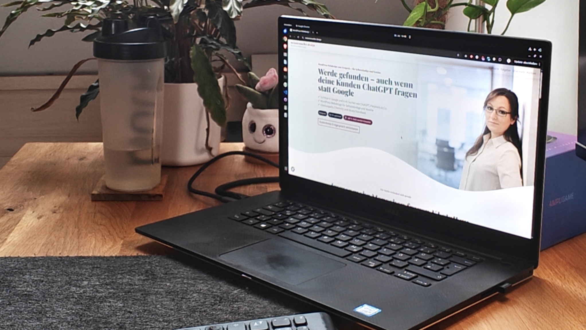 Melanie Müller sitzt an einem Schreibtisch mit Laptop, um eine Firmenwebsite zu erstellen
